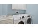 Functional laundry room with a utility sink, modern washer and dryer, and upper cabinets at 927 Jones Wynd, Wake Forest, NC 27587
