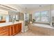 Luxurious primary bathroom featuring dual vanity, a glass shower, and a separate soaking tub at 1003 Red Sunset Dr, Apex, NC 27502