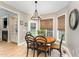 Cozy dining area features an oval table, wood floors, a modern chandelier and natural light from multiple windows at 1003 Red Sunset Dr, Apex, NC 27502