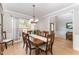 Elegant dining room featuring a wood table, decorative chandelier, and ample natural light at 1003 Red Sunset Dr, Apex, NC 27502