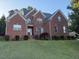 Charming two-story brick home with mature landscaping and a well-manicured front lawn at 1003 Red Sunset Dr, Apex, NC 27502
