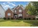 Classic two-story brick home featuring manicured landscaping and traditional architectural details at 1003 Red Sunset Dr, Apex, NC 27502