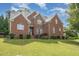 Beautiful two-story red brick home with a well-manicured lawn and lovely landscaping at 1003 Red Sunset Dr, Apex, NC 27502