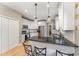 Modern kitchen with white cabinetry, stainless steel appliances, and breakfast bar with granite countertop at 1003 Red Sunset Dr, Apex, NC 27502