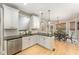 Bright kitchen with white cabinets, black countertops, and view to breakfast nook and Gathering room at 1003 Red Sunset Dr, Apex, NC 27502