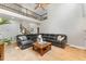 Expansive living room features a soaring ceiling, dark leather sofa, and a cozy fireplace at 1003 Red Sunset Dr, Apex, NC 27502