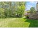 Spacious backyard with lush green grass, mature trees, and a deck at 1007 Grandover Dr, Durham, NC 27713