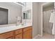 Bathroom with light wooden cabinets, double mirror and view to a shower with curtain at 1007 Grandover Dr, Durham, NC 27713