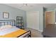 Cozy bedroom includes a black metal shelf, dresser and double doors to a closet at 1007 Grandover Dr, Durham, NC 27713