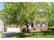 Traditional brick home featuring a two-car garage, a well-maintained lawn, and mature trees at 1007 Grandover Dr, Durham, NC 27713