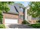 Lovely two-story brick home showcasing an attached garage, a concrete driveway, and well-manicured landscaping at 1007 Grandover Dr, Durham, NC 27713