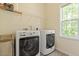 Functional laundry room with modern appliances, storage shelves, and a window at 1007 Grandover Dr, Durham, NC 27713