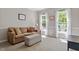 Comfortable living room with plush seating, soft carpet, and ample natural light from two windows at 1007 Grandover Dr, Durham, NC 27713