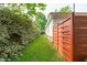 Side yard features healthy lawn, privacy fence, and mature hedges at 102 Fairgrove Way Way, Cary, NC 27511