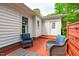 Cozy patio with red painted deck, wicker furniture and blue cushions for relaxation at 102 Fairgrove Way Way, Cary, NC 27511