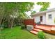 Cozy backyard featuring a red deck, green grass, and plenty of shade trees at 102 Fairgrove Way Way, Cary, NC 27511