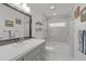 Bright bathroom with updated vanity, framed mirror, and tiled tub and shower with glass door at 102 Fairgrove Way Way, Cary, NC 27511