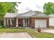 Inviting brick home with an attached garage, well-manicured lawn, and landscaped yard at 102 Fairgrove Way Way, Cary, NC 27511