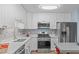 Bright kitchen featuring white cabinets, stainless steel appliances, light countertops, and a decorative backsplash at 102 Fairgrove Way Way, Cary, NC 27511
