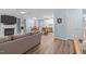 Open-concept living room with fireplace, laminate floors, neutral sofa and modern light fixture at 102 Fairgrove Way Way, Cary, NC 27511
