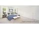 Bright bedroom showcasing a comfortable bed with blue bedding and two beige ottomans in front of bed at 104 S Buggy Dr # 71P, Benson, NC 27504