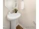 Stylish powder room featuring a modern pedestal sink, decorative mirror, and neutral wall color at 104 S Buggy Dr # 71P, Benson, NC 27504