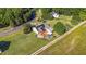 Aerial view of a home with a pool and deck surrounded by a well-manicured lawn and trees at 106 Contender Dr, Clayton, NC 27520