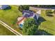 Aerial view of a home with solar panels, a backyard pool, a large deck and a well-manicured lawn at 106 Contender Dr, Clayton, NC 27520