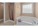 Bathroom features soaking tub with privacy glass window and brown shower curtain at 106 Contender Dr, Clayton, NC 27520