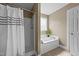 Bathroom featuring a shower and a soaking tub with a window allowing ample natural light at 106 Contender Dr, Clayton, NC 27520