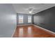 Bedroom features hardwood floors, two windows, ceiling fan, and neutral colored walls at 106 Contender Dr, Clayton, NC 27520