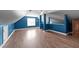 Large bonus room featuring hardwood floors, blue walls, custom woodwork, and ample natural light at 106 Contender Dr, Clayton, NC 27520