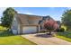 View of home featuring a two-car garage, and well-maintained landscaping with a healthy lawn and trees at 106 Contender Dr, Clayton, NC 27520