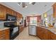 An open kitchen has stainless steel appliances and stone countertops with dark wood cabinets at 106 Contender Dr, Clayton, NC 27520