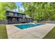 View of backyard with swimming pool and home with large windows at 106 Silverwood Ln, Cary, NC 27518