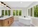 Spa-like bathroom with a wood vanity, soaking tub and a large window offering private views of surrounding greenery at 106 Silverwood Ln, Cary, NC 27518