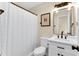 Bright bathroom features white vanity with dark hardware, framed mirror, and shower with textured white curtain at 106 Silverwood Ln, Cary, NC 27518