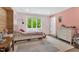 Cozy bedroom featuring a charming pink color scheme, a large window, and hardwood floors with an area rug at 106 Silverwood Ln, Cary, NC 27518