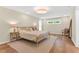 Bright bedroom featuring neutral decor, hardwood floors, and a large window overlooking greenery at 106 Silverwood Ln, Cary, NC 27518