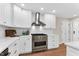 Bright kitchen features white cabinets, stainless steel appliances, and hardwood floors at 106 Silverwood Ln, Cary, NC 27518