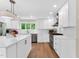 Modern kitchen with white cabinets, stainless steel appliances, island, and hardwood floors at 106 Silverwood Ln, Cary, NC 27518