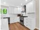 Bright kitchen features white cabinets, stainless steel appliances, and hardwood floors at 106 Silverwood Ln, Cary, NC 27518