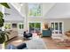 Bright living room with large windows, a modern blue chest, and access to an outdoor deck, ideal for relaxation at 106 Silverwood Ln, Cary, NC 27518