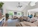 Bright, airy living room featuring vaulted ceilings, a ceiling fan, and large windows overlooking a lush backyard at 106 Silverwood Ln, Cary, NC 27518