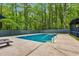 Private backyard swimming pool with surrounding concrete patio and lush greenery at 106 Silverwood Ln, Cary, NC 27518