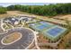 Wide aerial view showcasing community pool, tennis courts, parking, and common areas; meticulously landscaped at 109 Imagine Way, Pittsboro, NC 27312