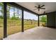 This covered patio with dark pillars and ceiling fans overlooks a grassy, gently sloping backyard at 109 Imagine Way, Pittsboro, NC 27312