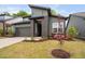 Modern gray home with dark brick entryway and professionally landscaped front yard, including pink azaleas at 109 Imagine Way, Pittsboro, NC 27312