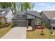 Charming gray home with modern architectural features and colorful flowers in the front yard at 109 Imagine Way, Pittsboro, NC 27312