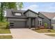 Well-maintained gray home featuring a two-car garage, professionally landscaped front yard, and modern design at 109 Imagine Way, Pittsboro, NC 27312